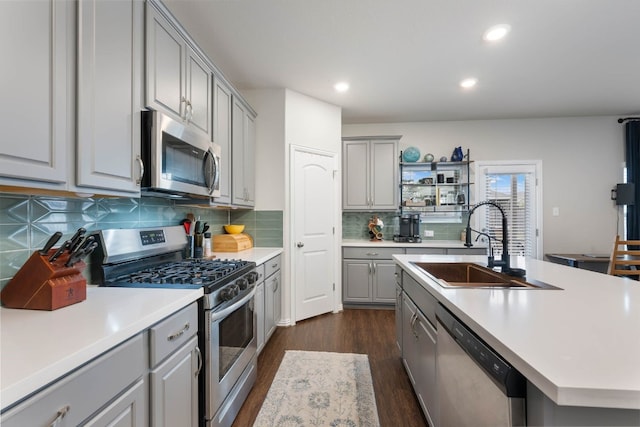 kitchen featuring gray cabinets, appliances with stainless steel finishes, dark hardwood / wood-style flooring, and tasteful backsplash