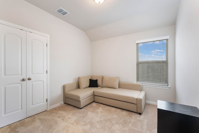 living room featuring light colored carpet and vaulted ceiling