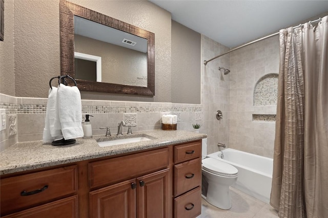 full bathroom featuring tile walls, tile patterned flooring, vanity, shower / tub combo, and toilet