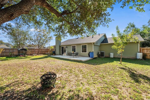 back of house with a fire pit, a yard, a patio area, and central air condition unit