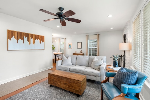 living room featuring ceiling fan and dark hardwood / wood-style floors