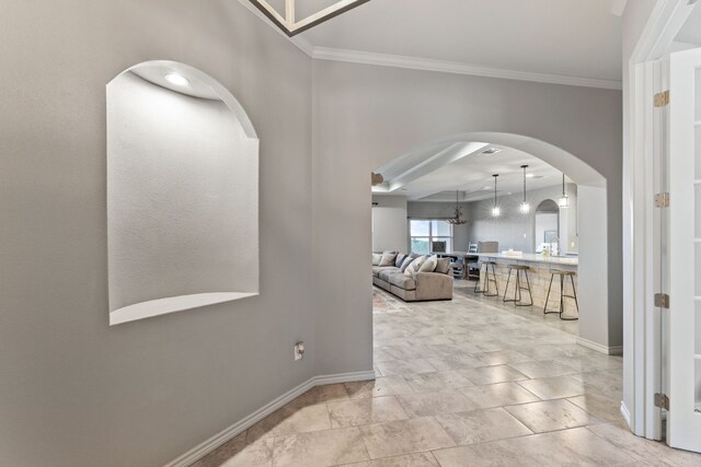 hallway with ornamental molding and light tile patterned floors