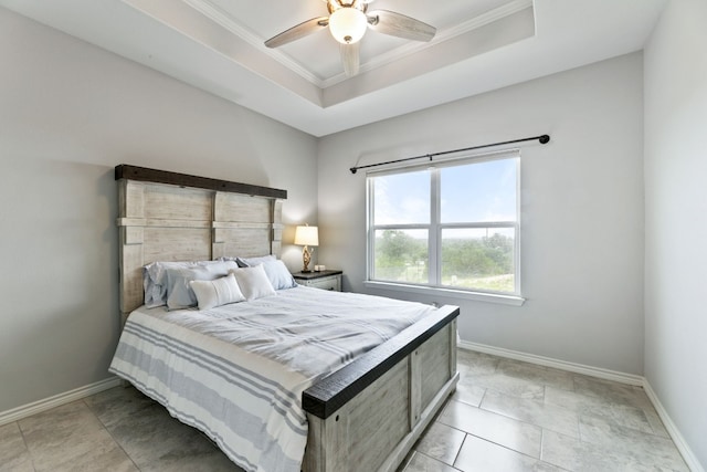 tiled bedroom featuring ceiling fan, ornamental molding, and a tray ceiling