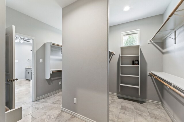 walk in closet with light tile patterned floors and ceiling fan