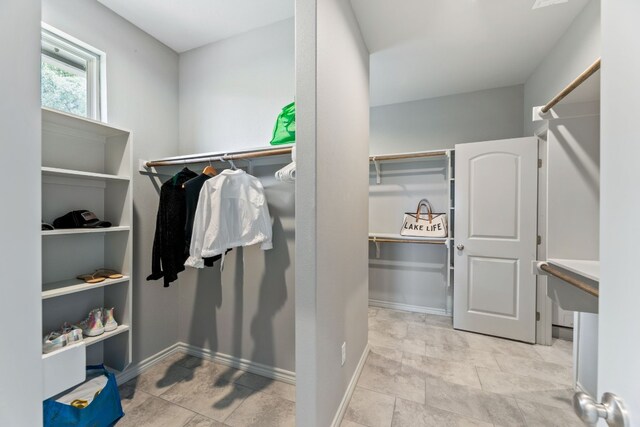 walk in closet with light tile patterned floors