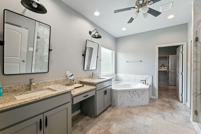 bathroom featuring tile patterned flooring, a tub, dual bowl vanity, and ceiling fan