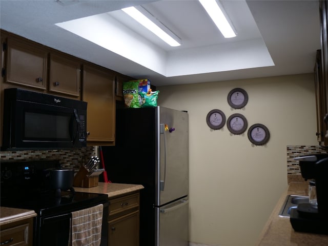 kitchen with decorative backsplash, electric range oven, and stainless steel refrigerator