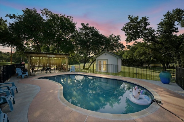 view of pool with a fenced in pool, a patio area, an outdoor structure, and fence