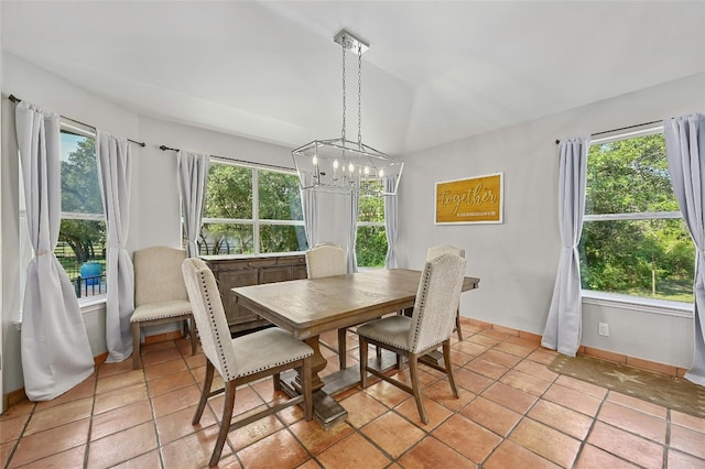 dining area with a notable chandelier, light tile patterned flooring, and baseboards