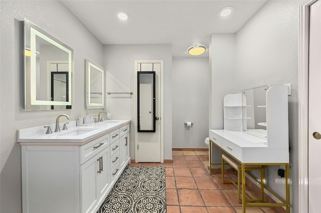 bathroom featuring recessed lighting, a sink, baseboards, and double vanity