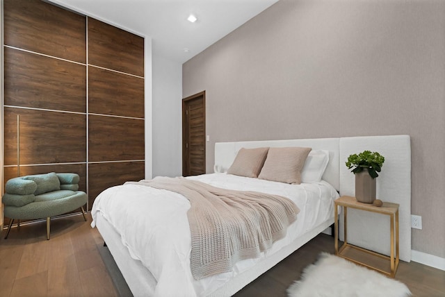 bedroom featuring baseboards, wood finished floors, and recessed lighting