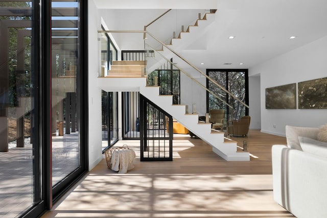 stairs with wood-type flooring and floor to ceiling windows