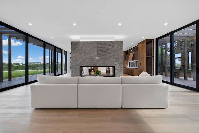 unfurnished living room with a wall of windows and light hardwood / wood-style flooring