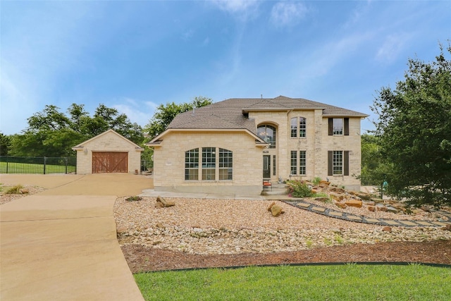 view of front of house featuring a garage and an outbuilding