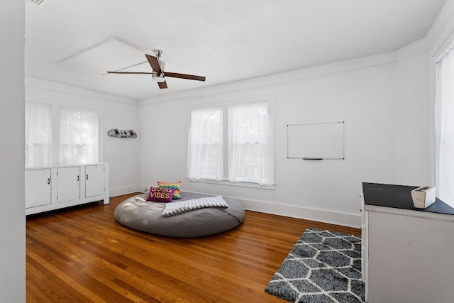 sitting room with ceiling fan, baseboards, and wood finished floors