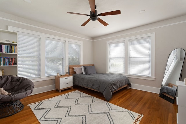 bedroom featuring dark wood-type flooring, multiple windows, and baseboards