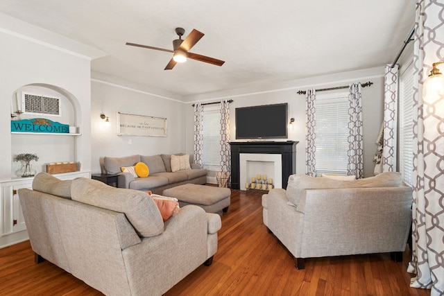 living room with a fireplace, wood finished floors, and a ceiling fan