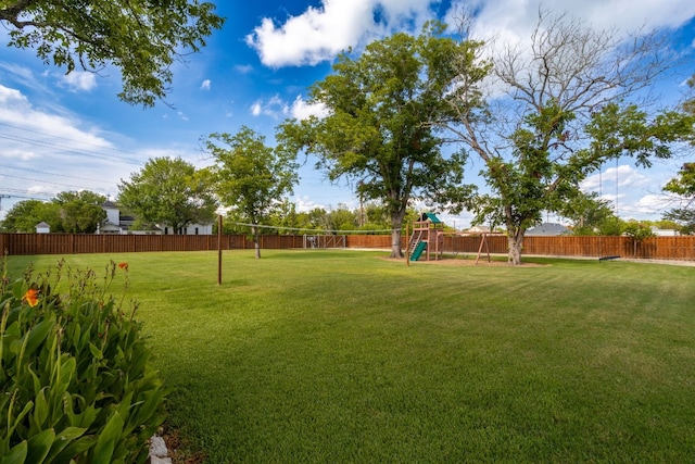 view of yard featuring a playground, a fenced backyard, and volleyball court