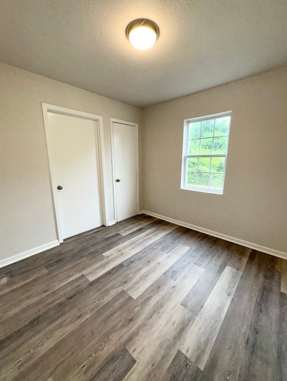 unfurnished bedroom featuring dark hardwood / wood-style floors and a textured ceiling