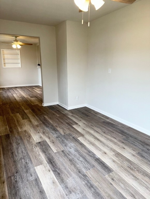 spare room with ceiling fan and dark wood-type flooring