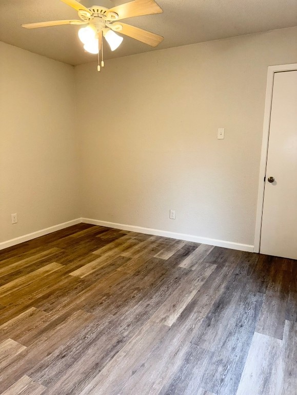 empty room featuring ceiling fan and dark hardwood / wood-style flooring