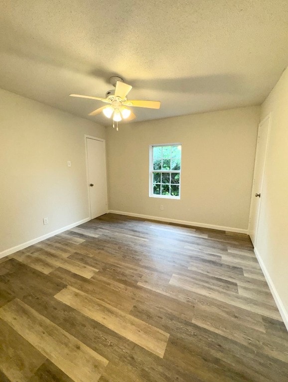 empty room with a textured ceiling, ceiling fan, and dark wood-type flooring