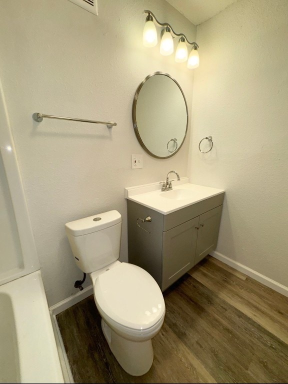 bathroom with vanity, wood-type flooring, and toilet