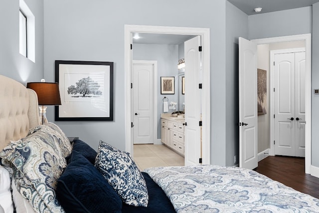 bedroom with light hardwood / wood-style flooring and connected bathroom