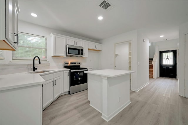 kitchen featuring appliances with stainless steel finishes, light hardwood / wood-style flooring, a healthy amount of sunlight, and sink