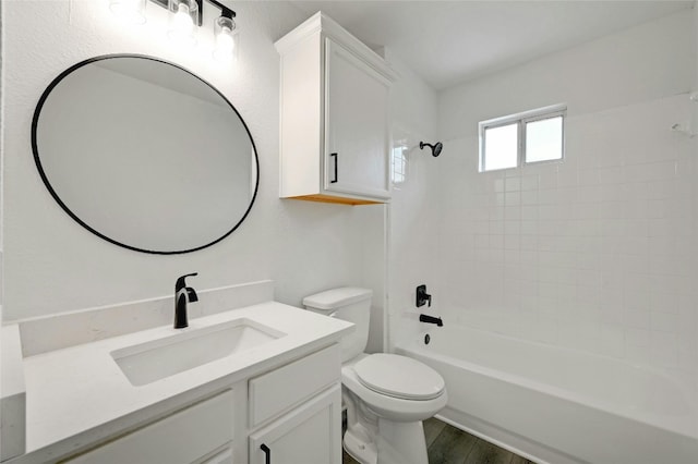 full bathroom featuring hardwood / wood-style floors, tiled shower / bath combo, toilet, and vanity