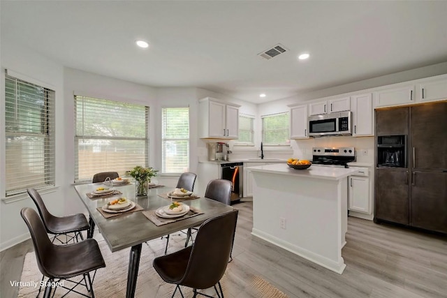 kitchen with white cabinets, sink, light wood-type flooring, and stainless steel appliances