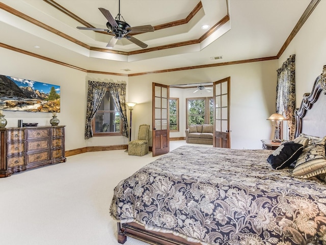 carpeted bedroom with ornamental molding, a raised ceiling, ceiling fan, and french doors