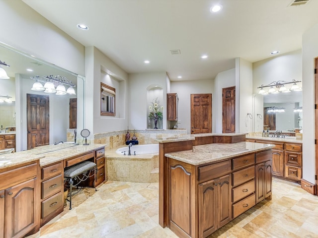 bathroom with vanity and tiled tub