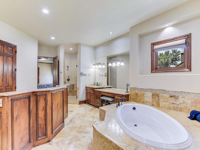 bathroom featuring vanity and independent shower and bath