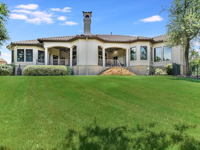 back of house featuring ceiling fan and a lawn