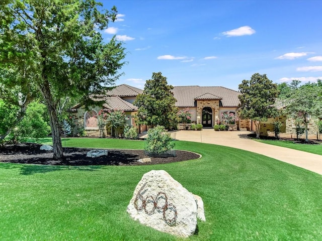 6000 Lantern View Dr, Jonestown, TX 78645 - mediterranean / spanish house with french doors, a front yard, a tiled roof, and stone siding