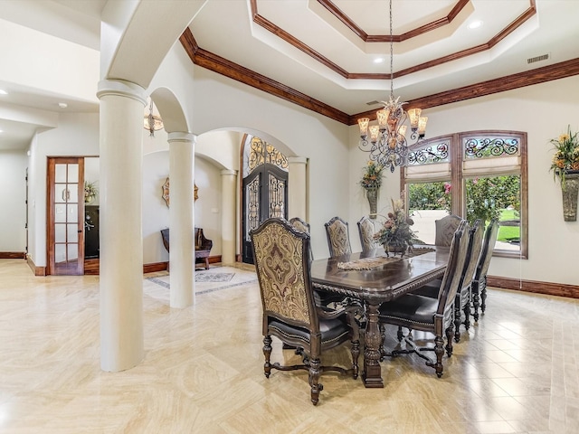 dining area featuring crown molding, decorative columns, a tray ceiling, french doors, and a chandelier