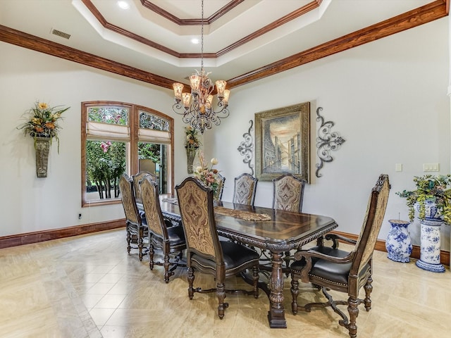 tiled dining area featuring a raised ceiling, ornamental molding, and a notable chandelier