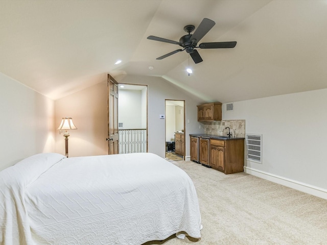 bedroom with lofted ceiling, sink, ceiling fan, ensuite bathroom, and light colored carpet