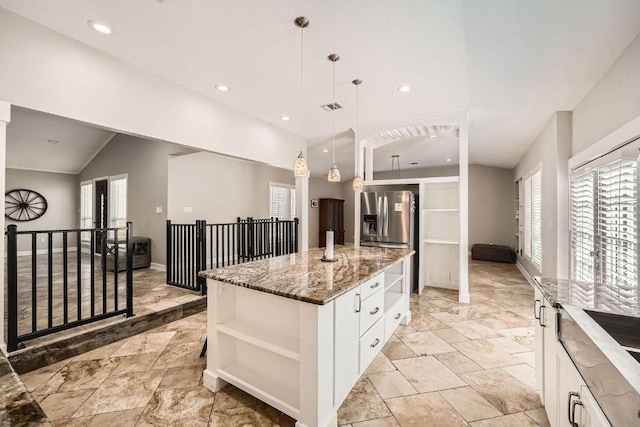 kitchen with light stone counters, white cabinets, a center island, and open shelves