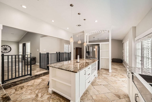7507 Davy Dr, Volente, TX 78641 - kitchen featuring open shelves, light stone countertops, a center island, healthy amount of natural light, and lofted ceiling