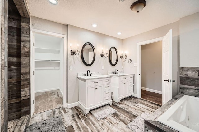 bathroom with a sink, two vanities, and wood finished floors