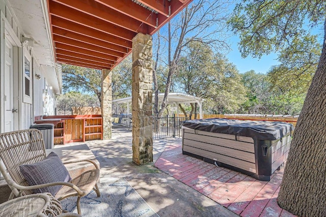 view of patio / terrace with a fenced backyard and a hot tub