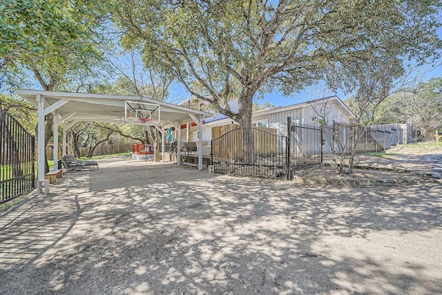 view of yard featuring a carport, driveway, fence private yard, and a gate