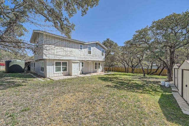 rear view of house with a lawn and a fenced backyard