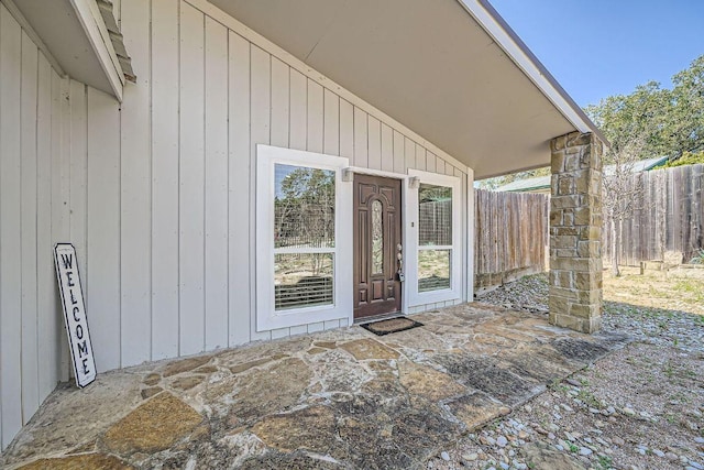 doorway to property featuring fence