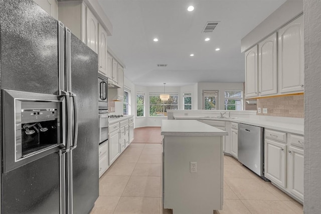 kitchen featuring white cabinetry, a center island, a healthy amount of sunlight, and appliances with stainless steel finishes