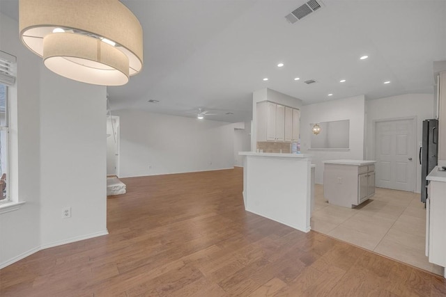 kitchen featuring a center island, light hardwood / wood-style flooring, and white cabinetry