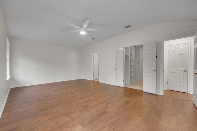 unfurnished bedroom featuring hardwood / wood-style flooring, a spacious closet, ceiling fan, and lofted ceiling