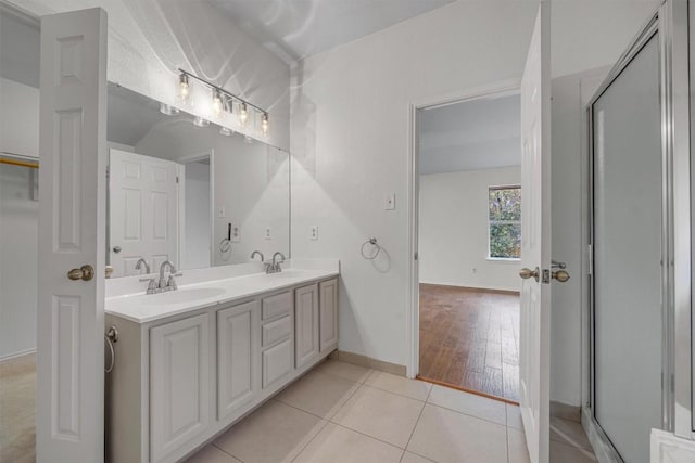 bathroom with tile patterned flooring, vanity, and walk in shower